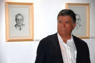 El artista Máximo Riol, delante de dos retratos (Foto TA)