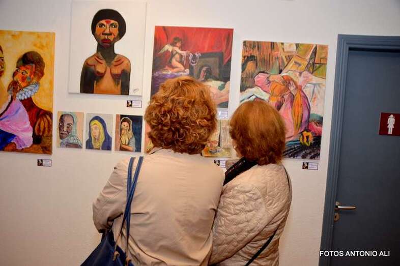 Dos personas observan cuadros de la exposición (Foto Antonio Alí)