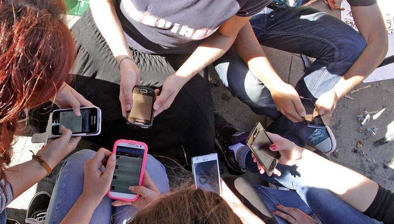 Jóvenes atentos a sus móviles (Foto Multimedia)
