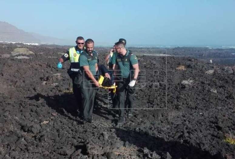 Dos guardias civiles y dos policías locales evacuando uno de los inmigrantes heridos de la patera (Foto Efe)