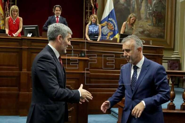 El recién nombrado presidente de Canarias, Ángel Víctor Torres (c), recibe la felicitación de su antecesor, Fernando Clavijo (i), tras finalizar el pleno de investidura. (Foto EFE / Cristóbal García)