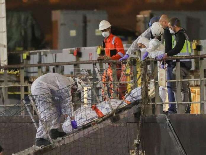 La Policía Nacional baja del buque el cadáver de uno de los inmigrantes rescatados a 800 kilómetros al sur de la isla de El Hierro (Foto EFE / Elvira Urquijo A.)