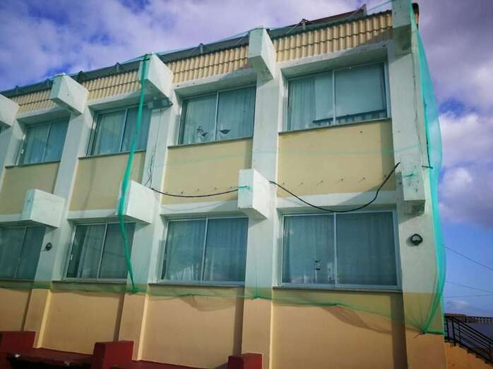 El colegio Príncipe de Asturias, en Telde, con la fachada protegida por el desprendimiento de cascotes (Foto TA)