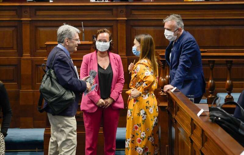 El consejero de Sanidad del gobierno de Canarias, Julio Pérez, saluda a las diputadas socialistas María del Pino González y Nira Fierro antes de comenzar el primer pleno del Parlamento regional celebrado bajo el estado de alarma (Foto Acfi press)