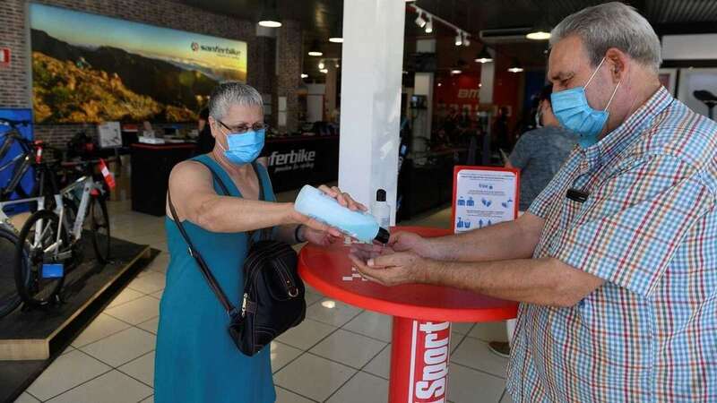 Una pareja se desinfectan las manos con gel hidroalcohólico (Foto TA)