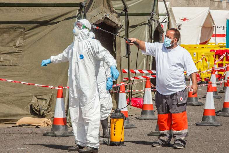 Desinfección de una persona con equipo de protección individual en el muelle de Arguineguín/Acfi Press.