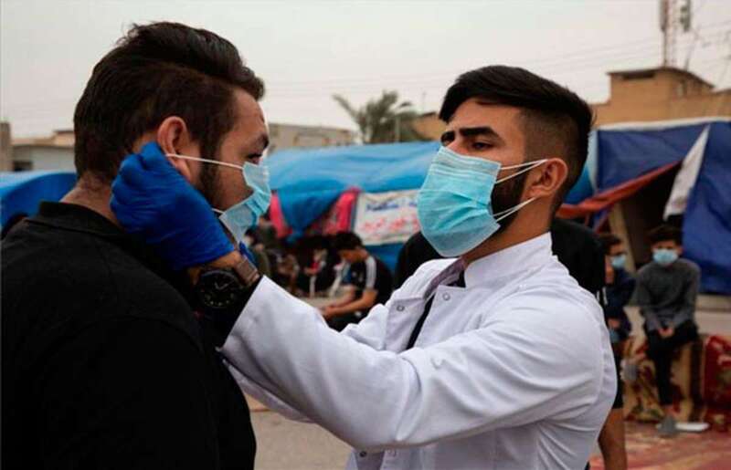 Joven pone la mascarilla a otro/TA.