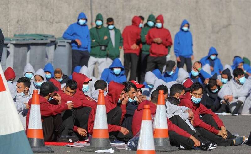 arios inmigrantes descansan en el muelle de Arguineguín tras ser rescatados por Salvamento Marítimo, este domingo, en Gran Canaria/EFE.