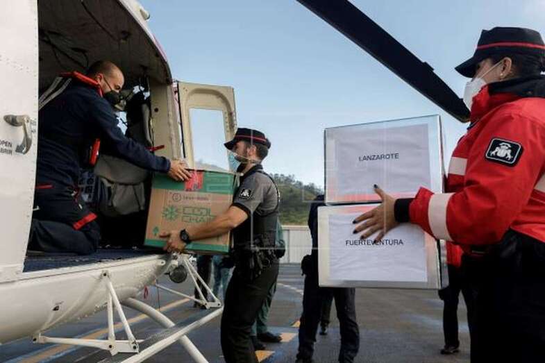 Varios policías meten las cajas que contienen la vacuna de Pfizer-BioNTech en un helicóptero / EFE