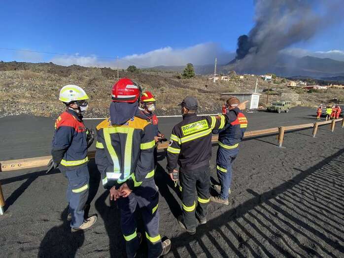 Bomberos en La Palma con el volcán al fondo/TA.