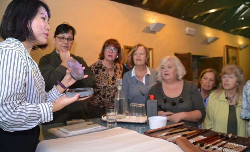 La profesora Liu Jingshan muestra al grupo de alumnos los útiles de escritura china (Foto TA)