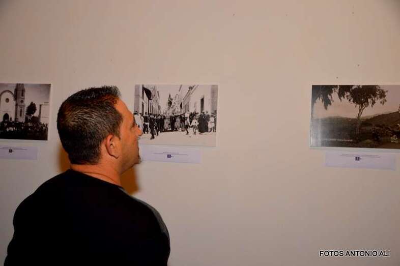 Una persona observa varias fotografías de la exposición (Foto TA)