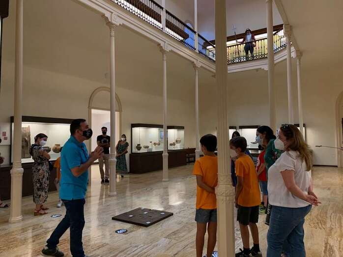 El arqueólogo Abel Galindo (i) con un grupo de menores en el interior de El Museo Canario/TA.