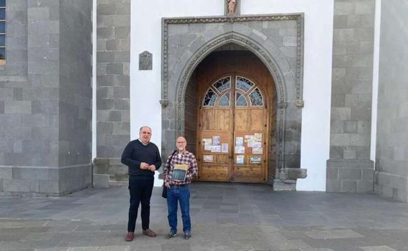 Juan Martel y Jesús Emiliano Rodríguez Calleja, con el libro y delante de la fachada de la iglesia de San Juan/C7.