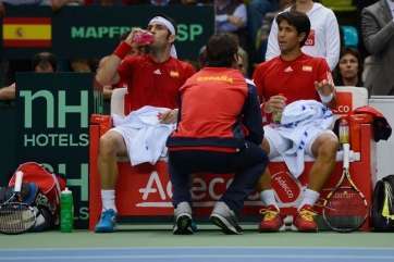 David Marrero (i) toma agua mientras Verdasco recibe instrucciones de Carlos Moyá, capitán del equipo (Foto Dennis Grombkowski-Getty Images)