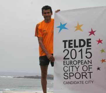 El atleta Juan Matías junto al logo de Telde Ciudad Europea del Deporte 2015 (Foto TA)