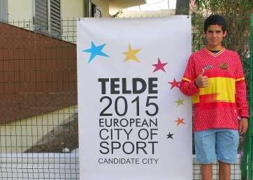El joven ciclista con la bandera de la candidatura (Foto TA)