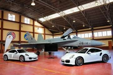 Los exclusivos Porsche 911 Carrera GTS (izquierda) y 911 Carrera Turbo S, junto al F-18 (Foto Diario de Avisos)