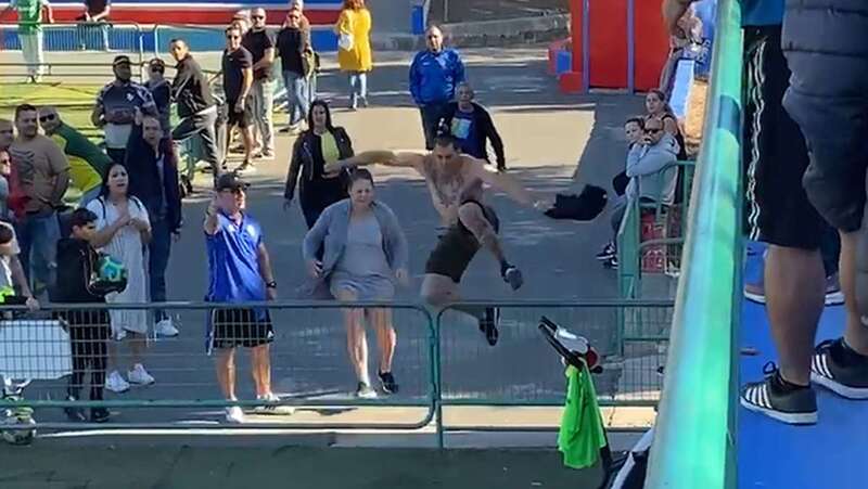La madre junto a su hijo cuando este salta una valla del campo para ir a agredir al árbitro (Foto TA)