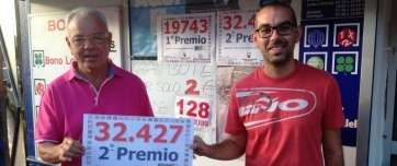 Los propietarios del Bazar Quintana muestran el cartel del premio del sorte de este jueves (Foto TA)