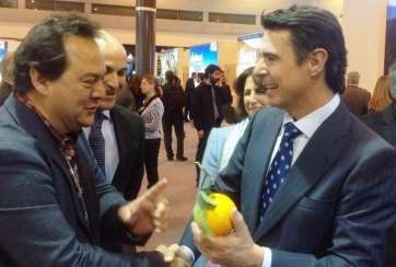 El ministro José Manuel Soria, con una naranja de Telde en la mano, saluda a Luis López, titular de la bodega La Higuera Mayor (Foto TA)