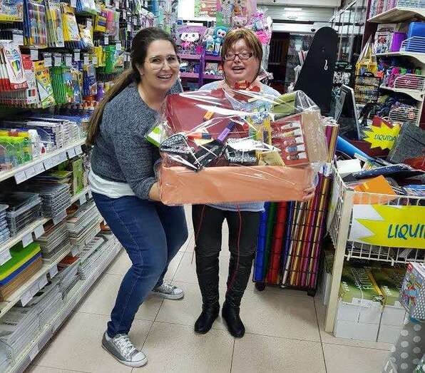 Una de las premiadas (d) con la cesta de material de oficina (Foto TA)