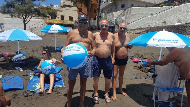 Usuarios de la playa de La Garita con balones y sombrillas de playa regaladas por Daikin (Foto TA)