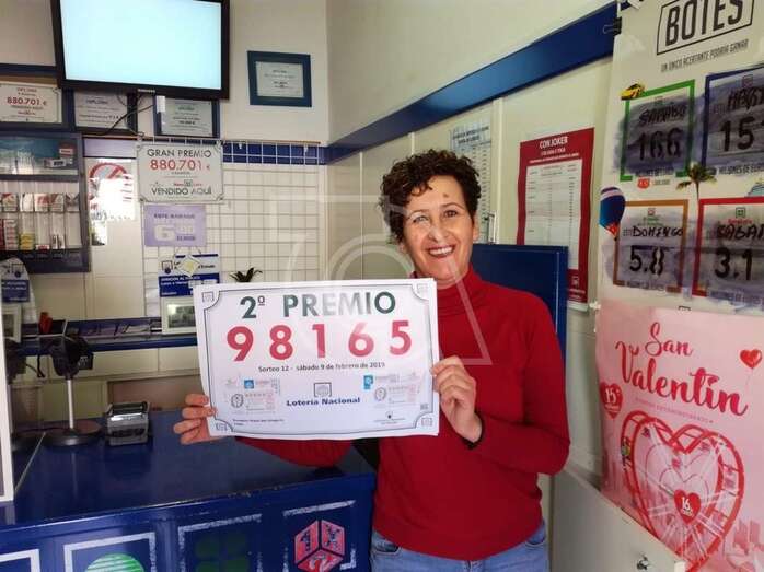 Toñi, empleada del negocio muestra el cartel alusivo al premio (Foto TA)