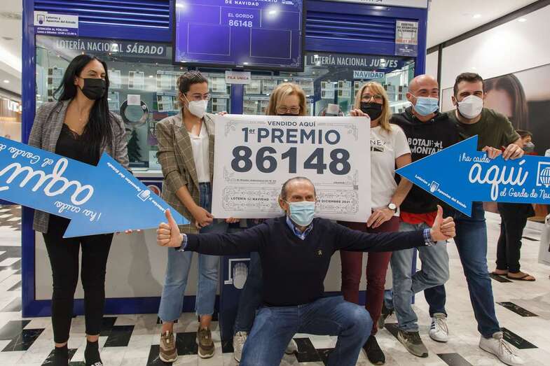 Trabajadores y clientes muestran jubilosos el cartel con el premio vendido/Acfi Press.