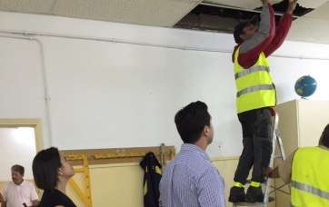 Operarios municipales arreglan los desperfectos ocasionados por la lluvia en el Colegio de Las Longueras,bajo la mirada de los ediles Leal y Ramos (Foto TA)