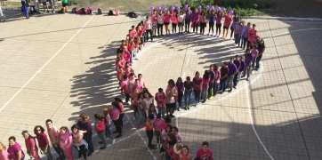 Alumnos y profesores del IES Guillermina Brito formando esta mañana un gran lazo violeta (Foto TA)