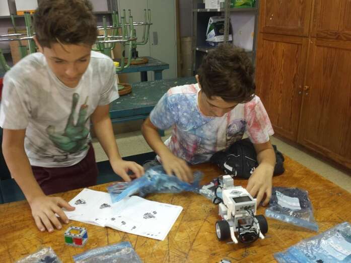 Dos alumnos montan uno de los robots durante el taller (Foto TA)