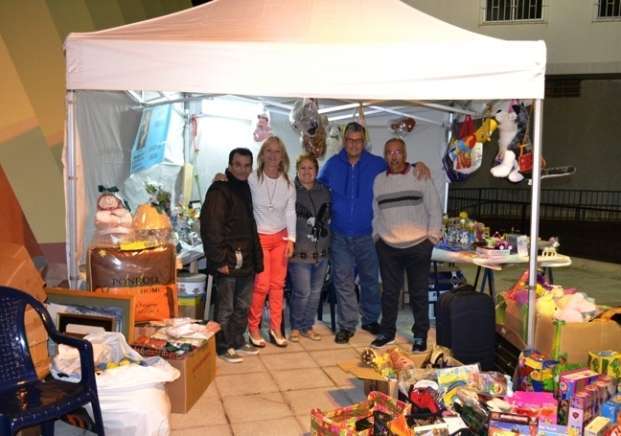 Miembros de Cáritas y vecinos, en la tómbola instalada en la plaza (Foto Daniel Ojeda)