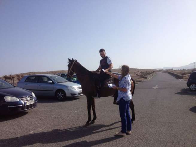 La concejala María González Calderín entrega propaganda a un jinete en Tufia (Foto TA)