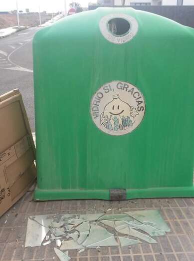 Vidrio roto que lleva más de un mes tirado junto al contenedor (Foto TA)