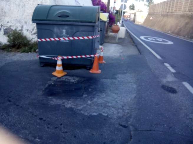 Imagen del contendor de basura tapando el orificio en la carretera de San Antonio (Foto TA)