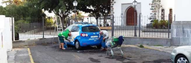 Lavado de un coche policial en una calle de San Juan, hace unos minutos (Foto TA)