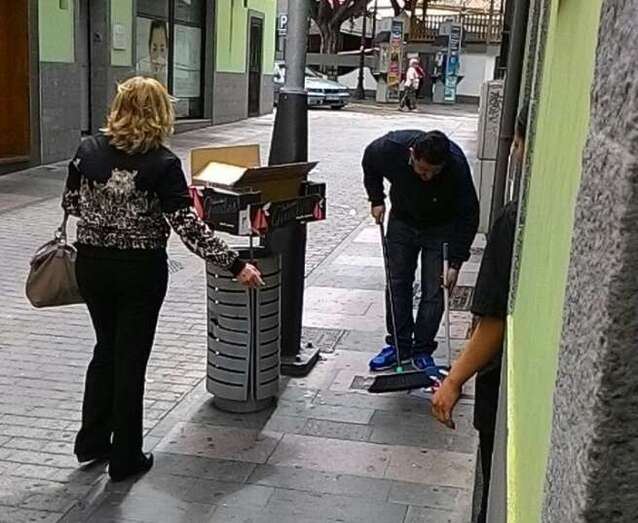 Comerciantes limpiando las papeleres de la calle (Foto TA)