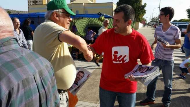 Muñoz, con camiseta roja, saluda a un conocido militante de Izquierda Unida de Telde (Foto TA)