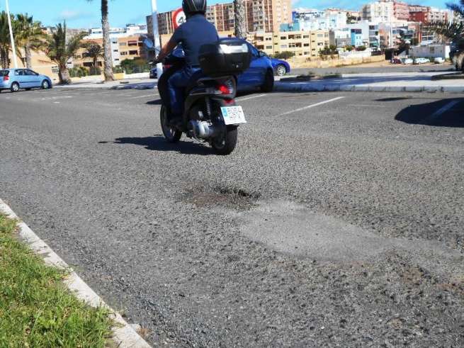 Motorista sortea un bache en la  vía principal de Salinetas en dirección hacia Melenara (Foto TA)
