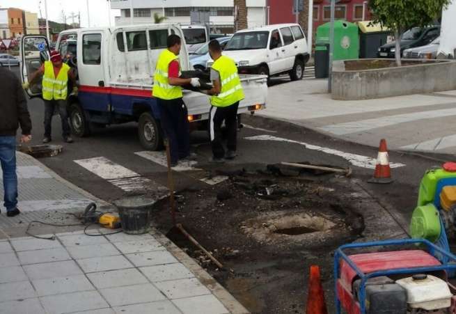 Los  operarios municipales reparan la arqueta y asfaltado que fueron levantados por la tromba de agua (Foto TA)