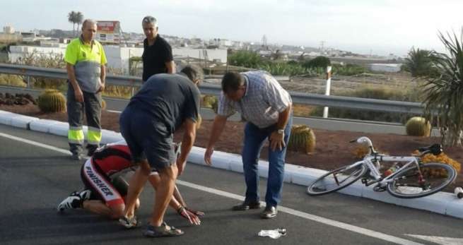 El ciclista es atendido por varias personas, a los pocos minutos de producirse el accidente (Foto TA)