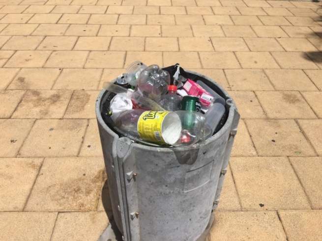 Papelera llena de basura en la plaza pública de Clavellinas (Foto TA)