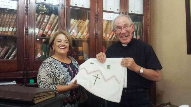 El párroco José María Cabrera recibe la mantelería de Neli Mejías (Foto TA)