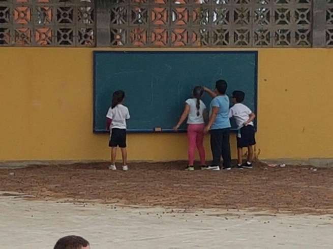 Alumnos usan la pizarra puesta en el patio del colegio (Foto TA)