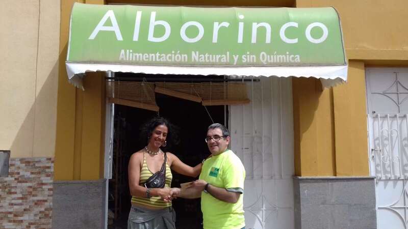 Belinda, trabajadora de Alborinco, hace entrega de la recaudación a Honorio Galindo (Foto TA)