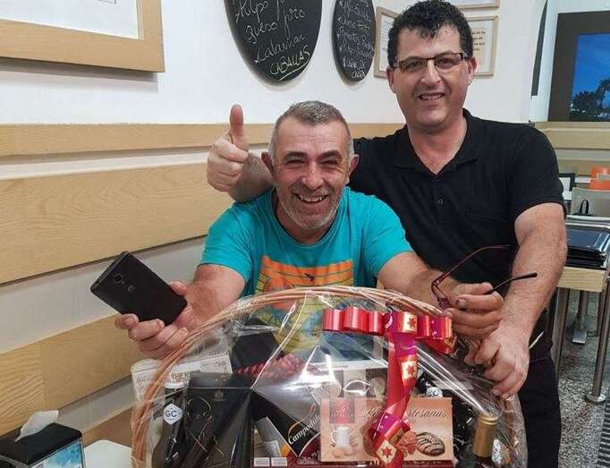 El cliente ganador de la cesta con un trabajador del restaurante de la estación (Foto TA)