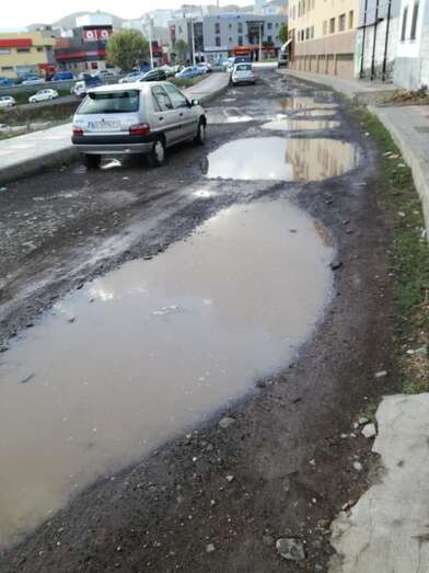 Grandes charcos en la calle sin asfaltar de Santiago de Compostela (Foto TA)