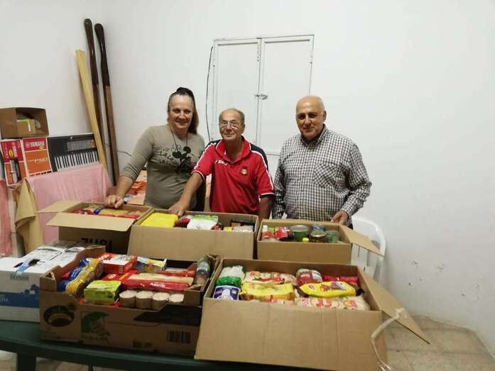 Directivos de la UD Las Huesas con el párroco Vicente Santana (d), en el momento de la entrega de los alimentos (Foto TA)