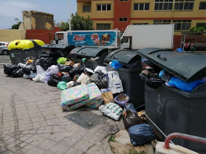 Bolsas de basura y residuos esparcidos en el entorno de los contenedores situados en la entrada principal a la playa (Foto TA)
